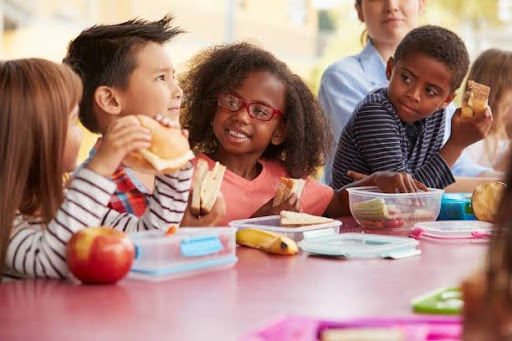 Kids eating nutritious food and interacting during lunch
