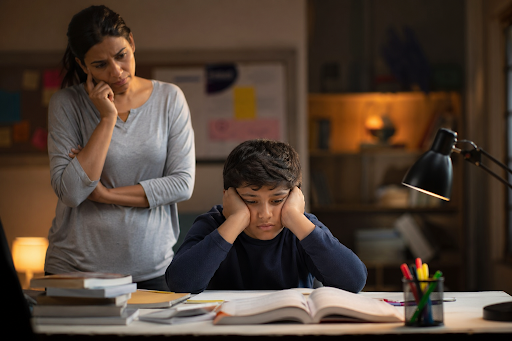Child feeling stressed with homework while parent looks concerned