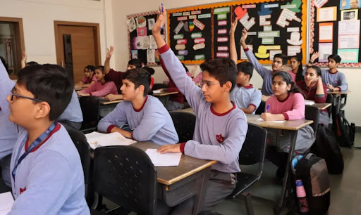 Students raising hands in class