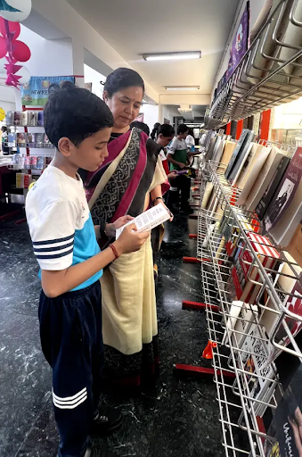 Student exploring books with teacher guidance in school library