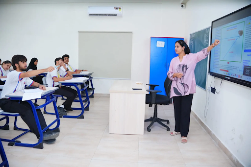 Teacher guiding students with digital tools in integrated learning setup