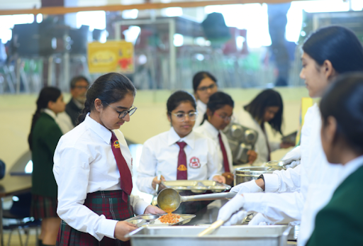 Students receiving balanced meals in a school dining hall