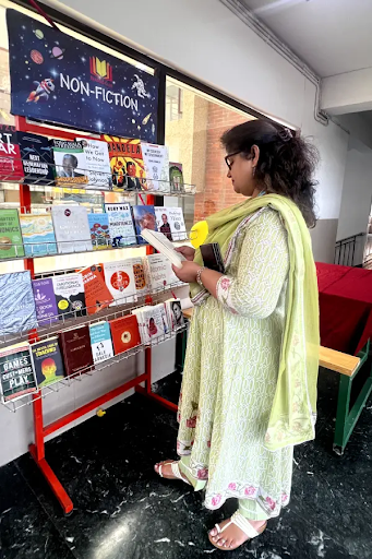 Teacher browsing non-fiction books in school library