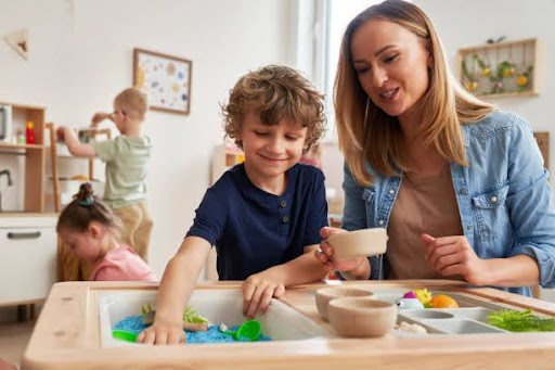Child learning through hands-on play with teacher