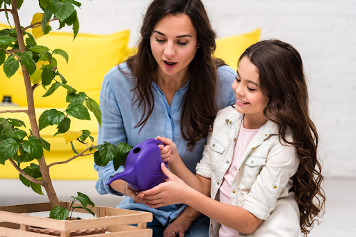 Parent and child watering a plant