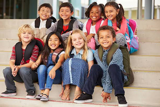 Happy students sitting together at school